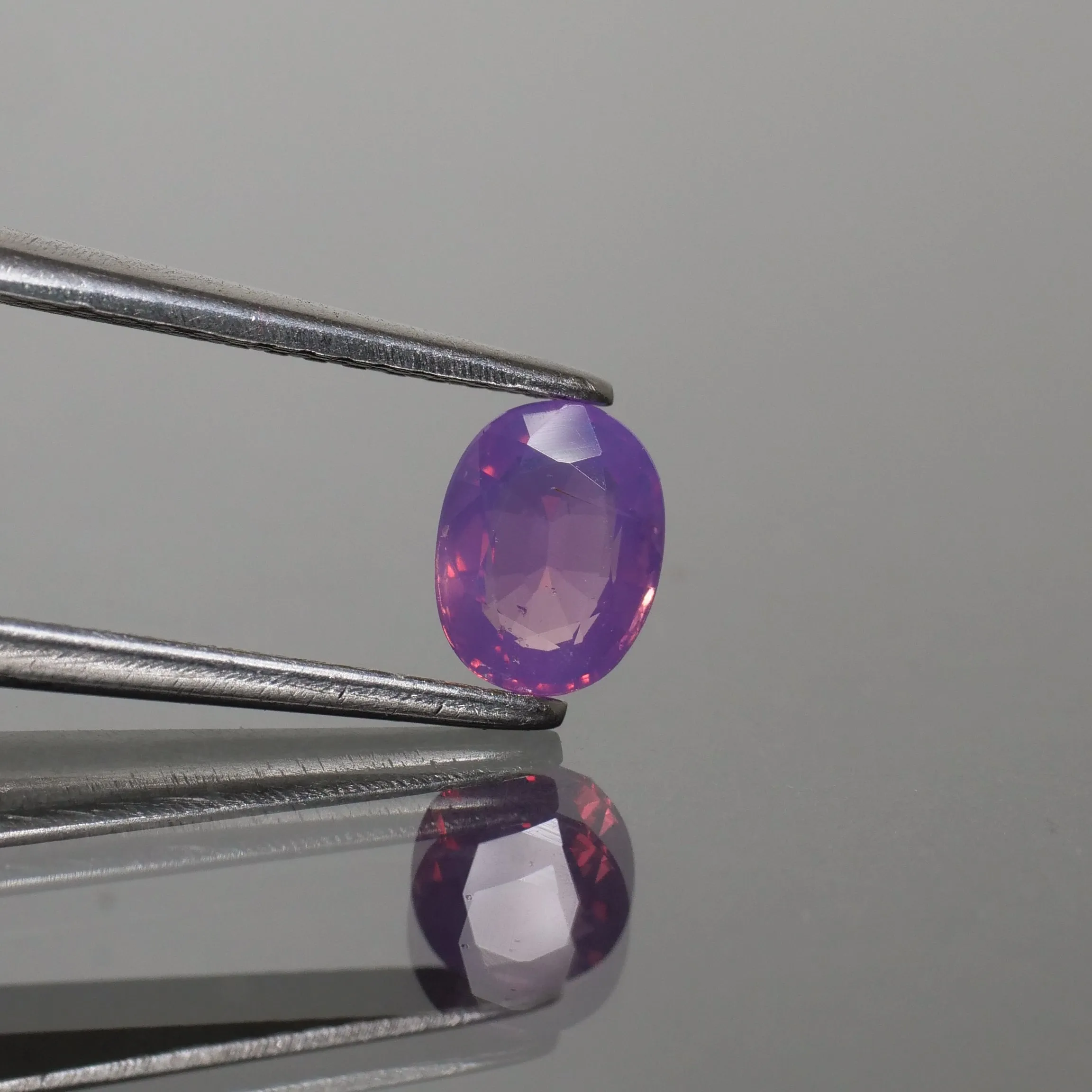 Sapphire opalescent | natural, pinkish purple, oval cut 5.8x4.5mm, VS 0.62ct